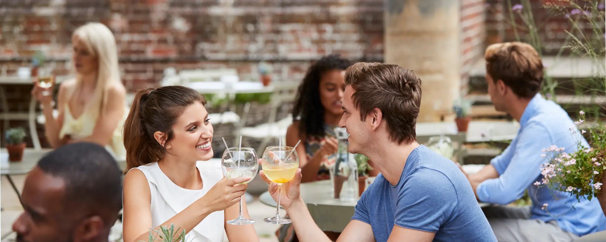 Man and woman toasting with cocktails at The Yard, an outdoor restaurant in Seneca, SC.