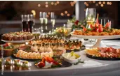 A buffet table with assorted appetizers, platters of finger foods, and glasses of drinks at a party or event at The Yard in Seneca, SC.